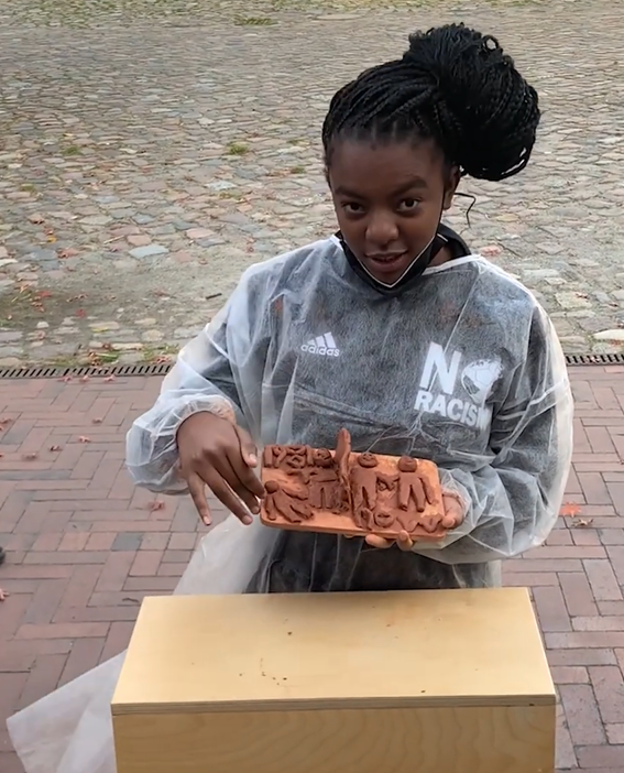 Eine Schülerin präsentiert ihre Tonskulptur.