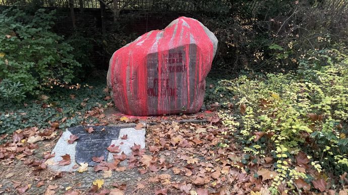 Stein mit Inschrift ist komplett mit roter Farbe übergossen worden.